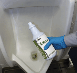 Person in blue glove holding white spray bottle with blue and white label over toilet bowl