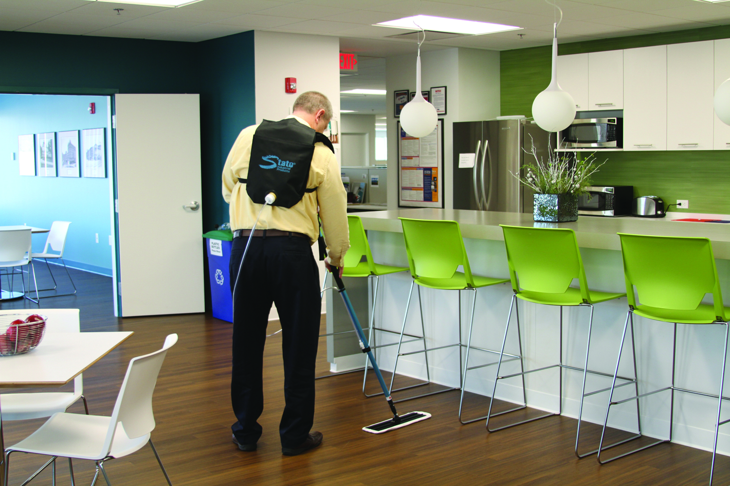 Backpack mopping system in use in a commercial building breakroom