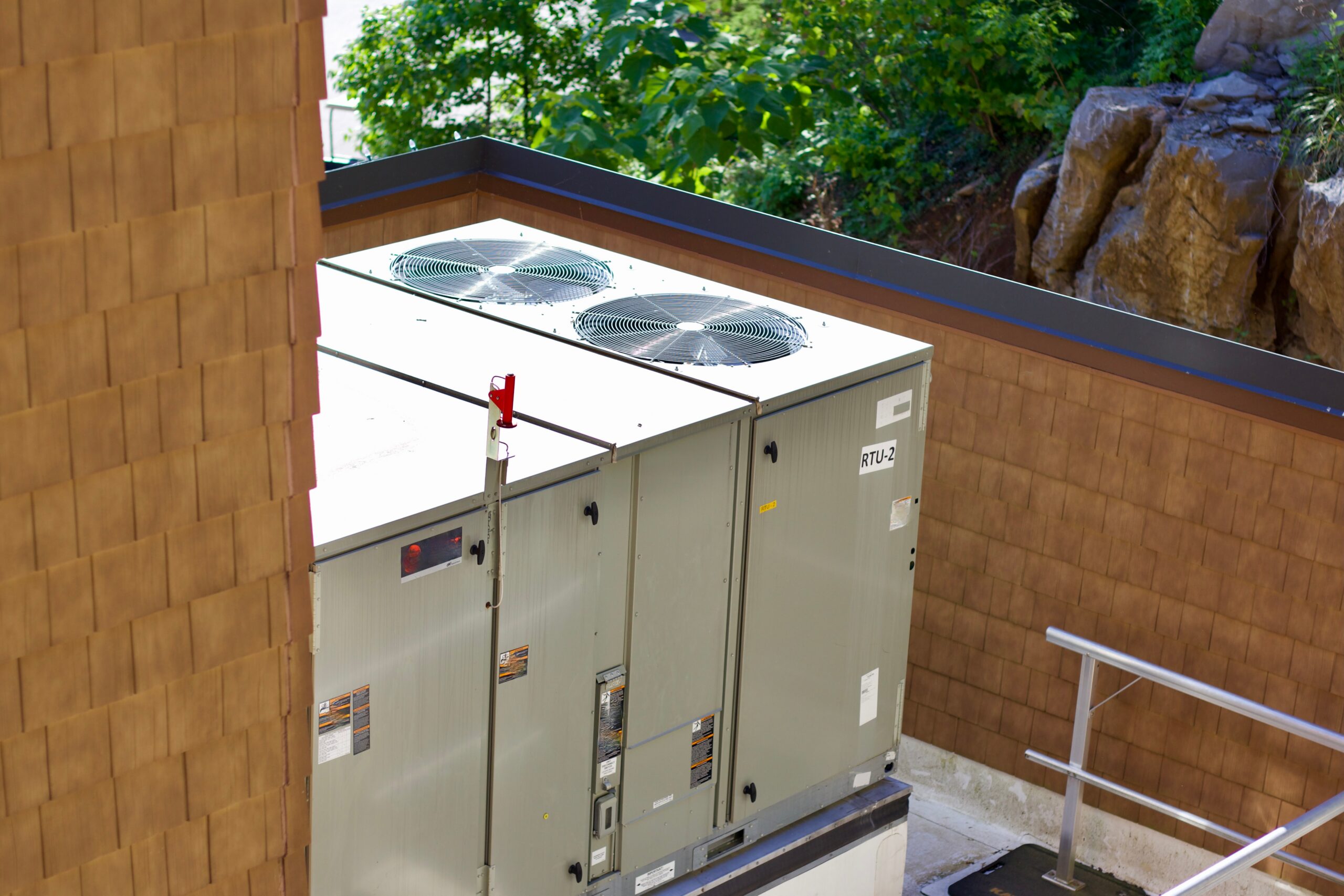 Commercial rooftop HVAC unit installed on wooden building exterior with ventilation panels visible
